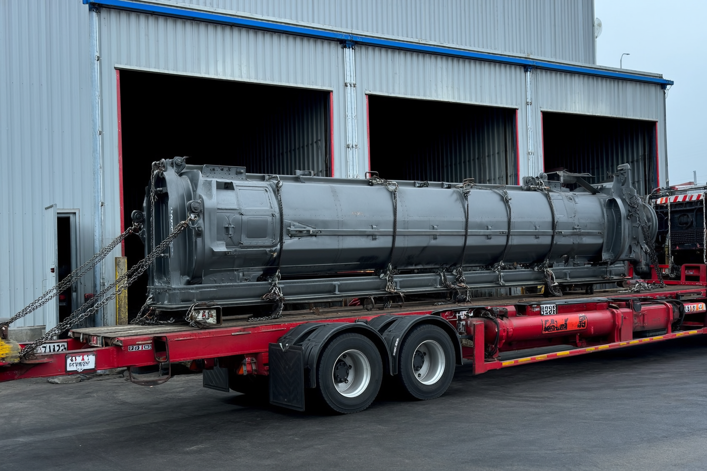 Flatbed freight truck loaded with heavy steel equipment